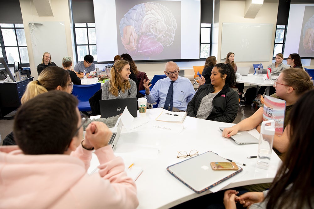 Steven Kornguth sits with undergraduates in his Autoimmune Diseases course