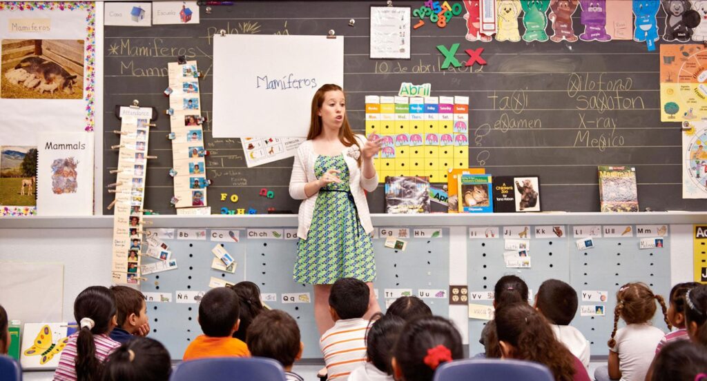 Teacher stands in front of a group of elementary students