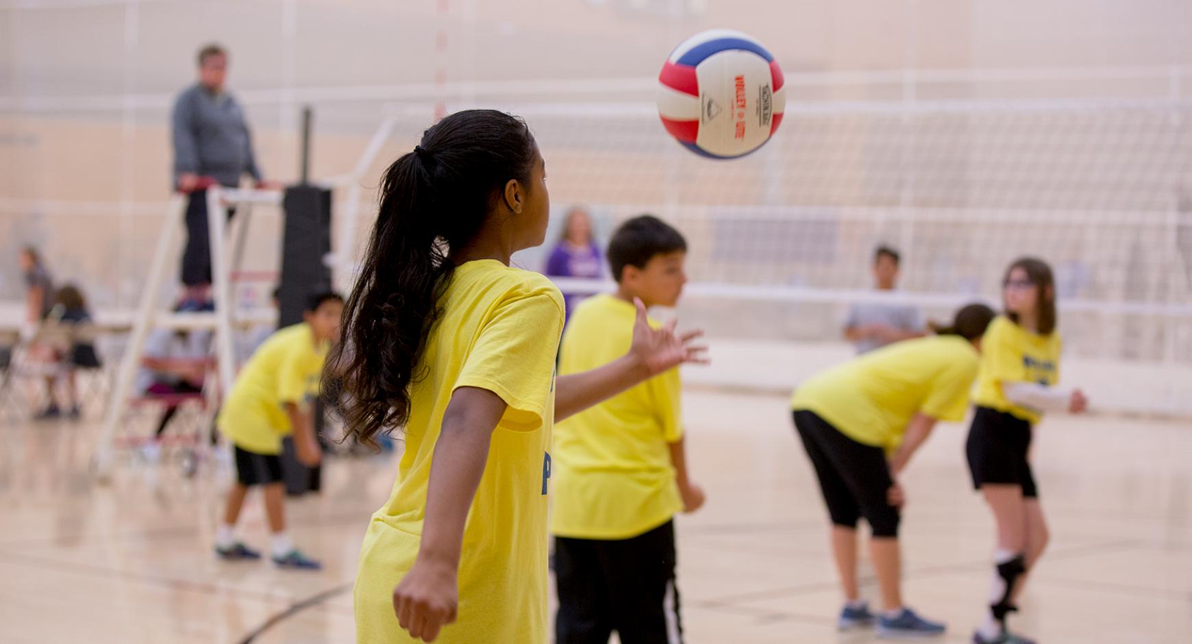 A girl prepares to serve a volleyball.