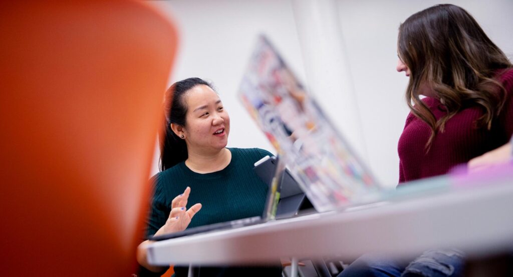 Assistant Professor Veronica Yan works with a graduate student during a seminar. 