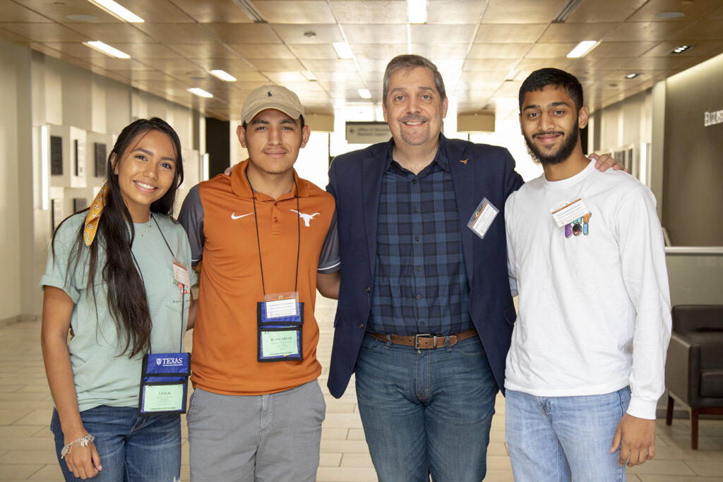 Dean Charles Martinez stands in the Sánchez Building with three students. 
