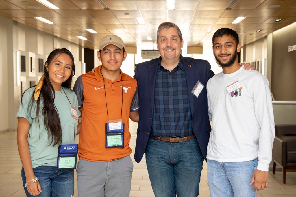 Dean Charles Martinez stands in the Sánchez Building with three students. 