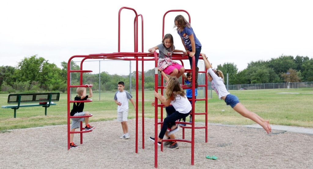 Children get exercise playing on a jungle gym.