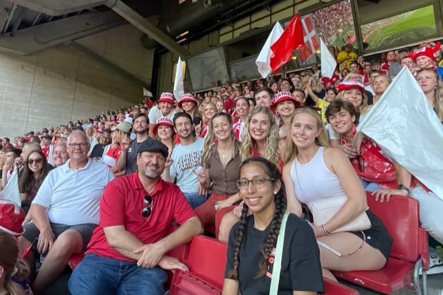 Students attend a football match with Dr. Bartholomew and Dr. Hunt.