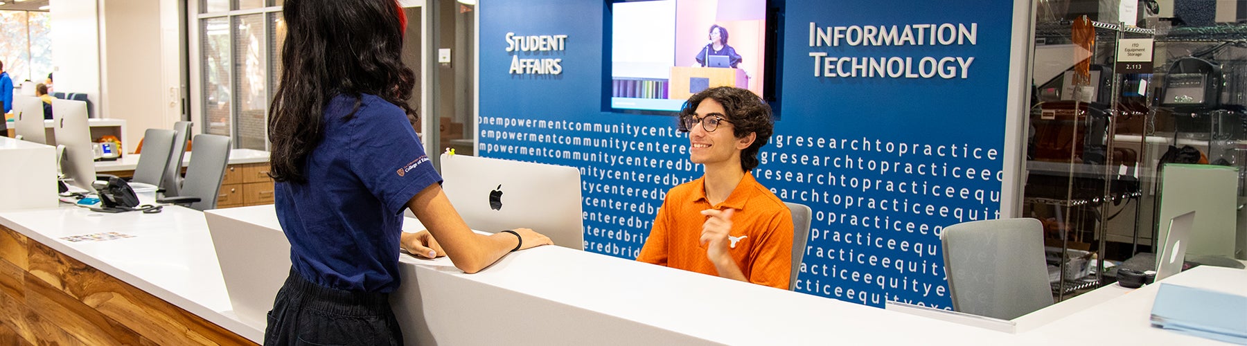 Photo o a student helping someone at the ITO desk.